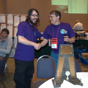 A happy Daniel Eppolito (left) poses with the HLS Trophy (foreground) and EQ Convention Co-Director John Weber (right). 